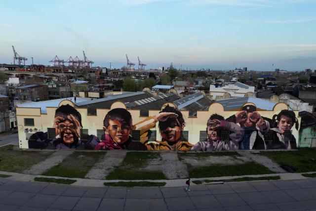 A man walks past a mural in Buenos Aires on September 20, 2024. (Photo by LUIS ROBAYO / AFP)