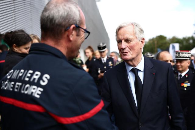 French Prime Minister Michel Barnier shakes hands with firefighters as he attends the 130th "Congres National des Sapeurs-Pompiers de France" (French firefighters congress), at the Parc des Expositions in Macon, central eastern France, on September 28, 2024. (Photo by Alex MARTIN / AFP)