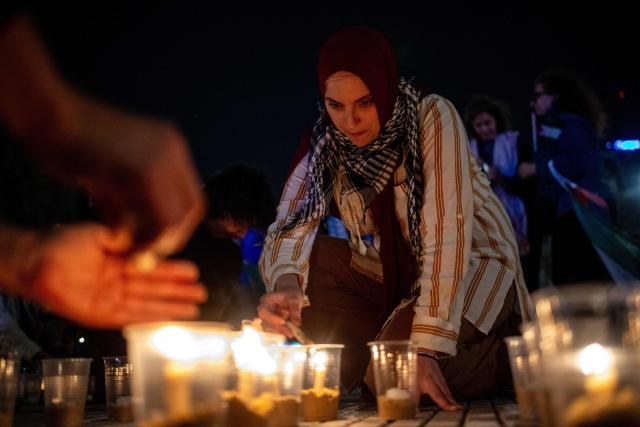 A demonstrator lights candles during a pro-Palestinian vigil within the framework of the first anniversary of the Israel-Hamas conflict in Buenos Aires on October 6, 2024. (Photo by TOMAS CUESTA / AFP)