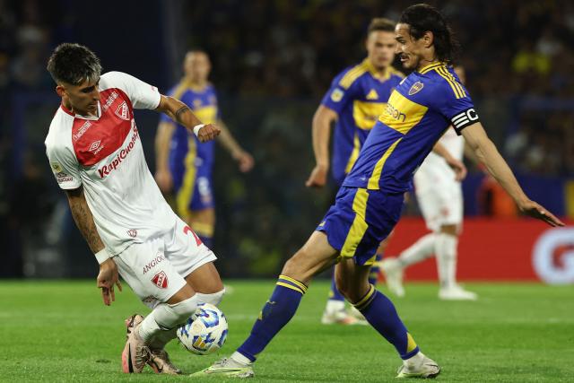 Argentinos Juniors' midfielder Alan Lescano (L) and Boca Juniors' Uruguayan forward Edinson Cavani fight for the ball during the 2024 Argentine Professional Football League tournament match between Boca Juniors and Argentino Juniors at the Alberto Jose Armando 'La Bombonera' Stadium in Buenos Aires on October 6, 2024. (Photo by ALEJANDRO PAGNI / AFP)