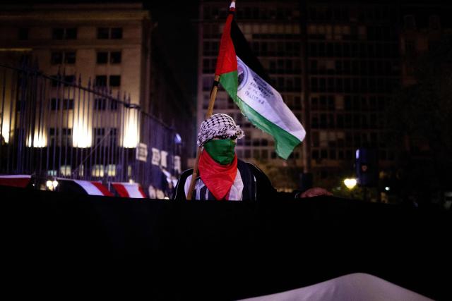 A demonstrator holds a Palestinian flag during a pro-Palestinian vigil within the framework of the first anniversary of the Israel-Hamas conflict in Buenos Aires on October 6, 2024. (Photo by TOMAS CUESTA / AFP)