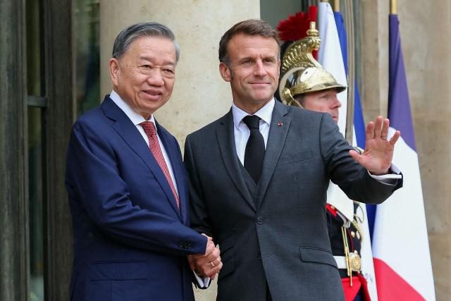 France's President Emmanuel Macron (R) greets Vietnam's President To Lam (C) upon his arrival prior to a working lunch at the presidential Elysee Palace, in Paris on October 7, 2024. (Photo by ALAIN JOCARD / AFP)