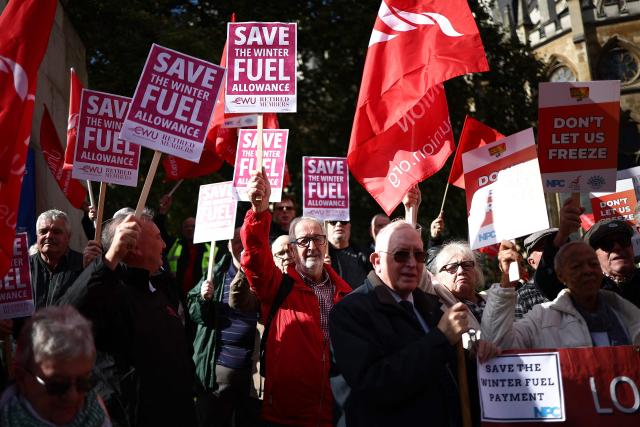 People gather with placards outside parliament to protest against the cut in winter fuel allowance, in central London on October 7, 2024. (Photo by HENRY NICHOLLS / AFP)