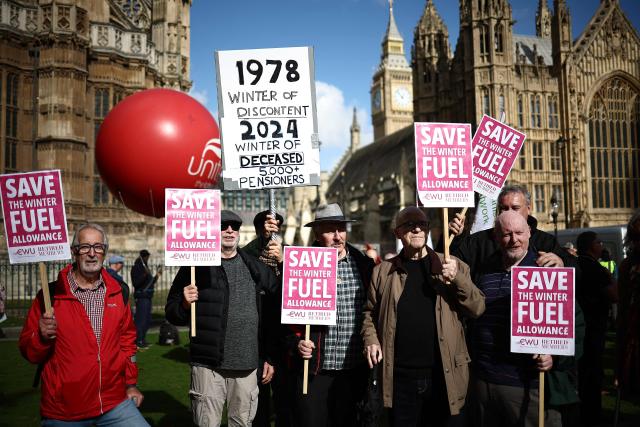 People gather with placards outside parliament to protest against the cut in winter fuel allowance, in central London on October 7, 2024. (Photo by HENRY NICHOLLS / AFP)