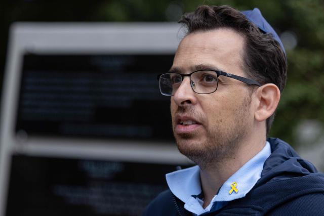 Yuval Dancyg, son of late Polish-born Israeli historian Alex Dancyg, looks on during a commemoration ceremony for his father after a memorial plaque was unveiled at the Jewish cemetery in Warsaw, Poland on October 7, 2024, on the one-year anniversary of the Hamas attack on Israel which triggered the war in Gaza. Alex Dancyg had been abducted from his home in the Nir Oz kibbutz by Hamas militants during the attack on October 7, 2023 on Israel. He died in captivity in Gaza in 2024. (Photo by Wojtek RADWANSKI / AFP)