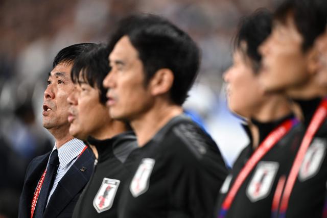 Japan's coach Hajime Moriyasu (L) sings the national anthem before the FIFA World Cup 2026 Asian zone qualifiers football between Japan and Australia at Saitama Stadium in Saitama on October 15, 2024. (Photo by Philip FONG / AFP)