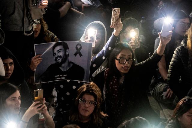 Fans light cellphones as they pay tribute to the late British singer Liam Payne at the Revolucion monument in Mexico City on October 17, 2024. Tributes poured for British singer Liam Payne, a former member of the best-selling boy band One Direction, after he plunged to his death from the balcony of a Buenos Aires hotel on October 16. (Photo by Yuri CORTEZ / AFP)