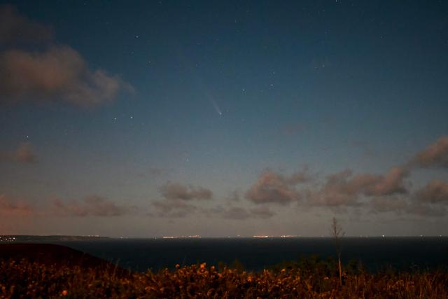 This photograph taken on October 17, 2024, shows Comet C/2023 A3 Tsuchinshan-Atlas in the sky above "Cap Frehel" in Plevenon, western France. (Photo by Damien MEYER / AFP)