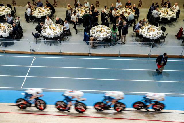 Cyclists race past spectators having a meal during the first round of  the women's 4000 meter team pursuit race of the UCI Track Cycling World Championships in Ballerup, Denmark, on October 17, 2024. (Photo by Mads Claus Rasmussen / Ritzau Scanpix / AFP) / Denmark OUT