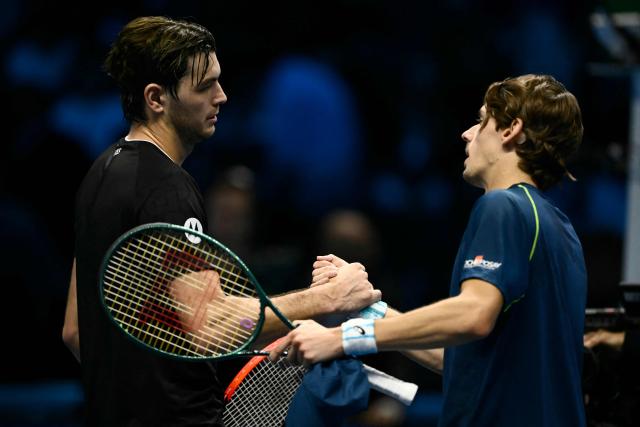 USA's Taylor Fritz shakes hands with Australia's Alex De Minaur (R) after victory in their match at the ATP Finals tennis tournament in Turin on November 14, 2024. (Photo by Marco BERTORELLO / AFP)