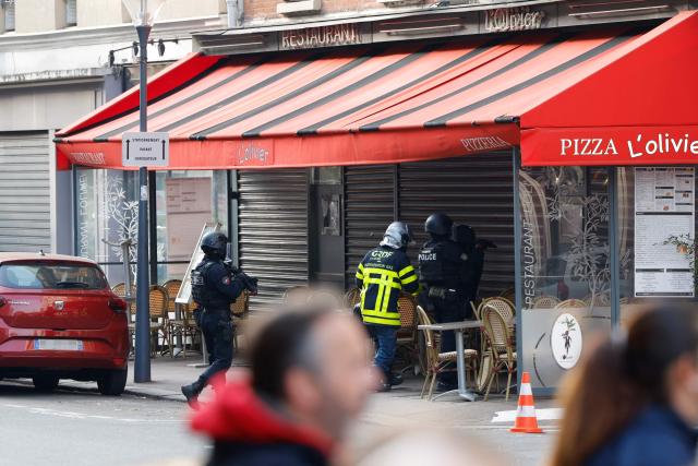 Police officers stand outside the restaurant "Pizzas L'Olivier" in Issy-les-Moulineaux, suburbs of Paris, on November 16, 2024, where the owner of the restaurant is "entrenched" in his establishment and "holding several employees" Paris fire department (Brigade des sapeurs-pompiers de Paris - BSPP)told AFP. A large police force surrounded the restaurant, a few dozen meters from the Paris ring road, AFP journalists observed, on November 16, 2024. (Photo by Ian LANGSDON / AFP)