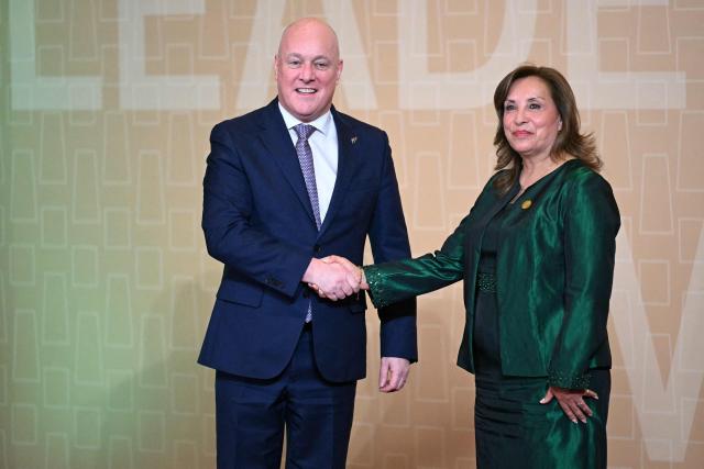 Peru's President Dina Boluarte (R) greets New Zealand's Prime Minister Christopher Luxon upon his arrival at the APEC Economic Leaders’ Meeting (AELM) at the Convention Centre in Lima, on November 16, 2024. (Photo by Luis ACOSTA / AFP)