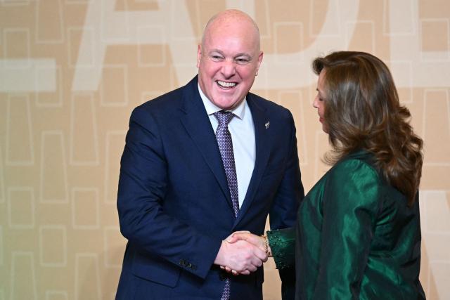 Peru's President Dina Boluarte (R) greets New Zealand's Prime Minister Christopher Luxon upon his arrival at the APEC Economic Leaders’ Meeting (AELM) at the Convention Centre in Lima, on November 16, 2024. (Photo by Luis ACOSTA / AFP)