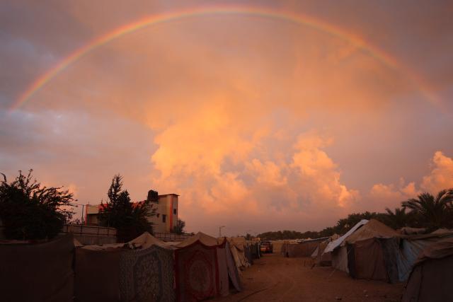 A rainbow is seen over a makeshift camp in al-Zawayda in the central Gaza Strip on November 18, 2024, amid the ongoing war between Israel and Hamas. (Photo by BASHAR TALEB / AFP)