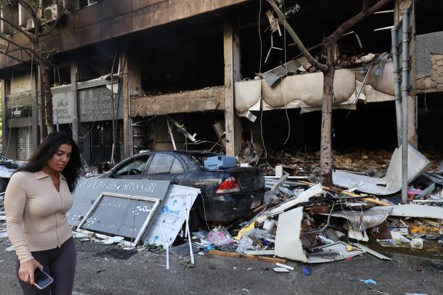 A woman walks past the debris of a building, targeted in an Israeli airstrike the previous day, in Beirut’s Mar Elias Street on November 18, 2024, amid the ongoing war between Israel and Hezbollah. (Photo by ANWAR AMRO / AFP)