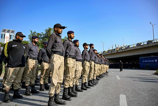 Police personnel align before being deployed near a Red Zone area blocked with shipping containers to hinder a rally by members of jailed former prime minister Imran Khan's Pakistan Tehreek-e-Insaf (PTI) party demanding his release, in Islamabad on November 24, 2024. Pakistan's capital was under total lockdown on November 24, with mobile internet cut and thousands of police flooding the streets as supporters of jailed ex-prime minister marched on the city. (Photo by Aamir QURESHI / AFP)