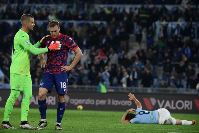 Bologna's Italian midfielder #18 Tommaso Pobega is comforted by teammate Bologna's Italian goalkeeper #34 Federico Ravaglia after he received a red card as Lazio's French midfielder #08 Matteo Guendouzi reacts during the Italian Serie A football match between Lazio and Bologna at the Olympic Stadium in Rome on November 24, 2024. (Photo by Filippo MONTEFORTE / AFP)