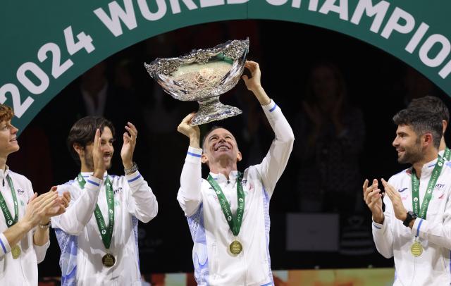 Italy's captain Filippo Volandri raises the trophy with teammates after winning the Davis Cup Finals at the Palacio de Deportes Jose Maria Martin Carpena arena in Malaga, southern Spain, on November 24, 2024. (Photo by Thomas COEX / AFP)