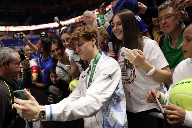 Italy's Jannik Sinner takes a selfie photo with fans after his team's victory over Netherlands in the Davis Cup Finals at the Palacio de Deportes Jose Maria Martin Carpena arena in Malaga, southern Spain, on November 24, 2024. (Photo by Thomas COEX / AFP)