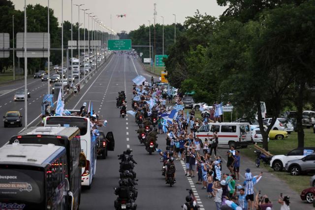 The bus transporting the players of Argentina's Racing, winners of the Copa Sudamericana football tournament, heads to the Obelisk in Buenos Aires, upon leaving Ezeiza International Airport, Buenos Aires Province, on November 24, 2024. The Argentine team was crowned at the La Nueva Olla stadium in Asunción on the eve after decisively defeating Brazil's Cruzeiro 3-1. (Photo by Emiliano Lasalvia / AFP)