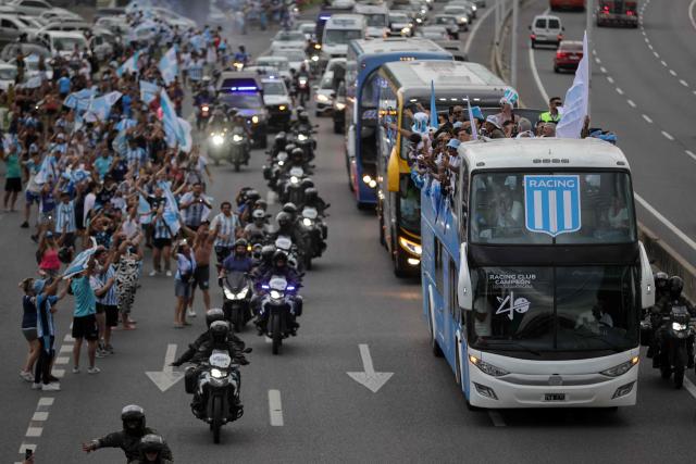 The bus transporting the players of Argentina's Racing, winners of the Copa Sudamericana football tournament, head to the Obelisk in Buenos Aires, upon leaving Ezeiza International Airport, Buenos Aires Province, on November 24, 2024. The Argentine team was crowned at the La Nueva Olla stadium in Asunción on the eve after decisively defeating Brazil's Cruzeiro 3-1. (Photo by Emiliano Lasalvia / AFP)