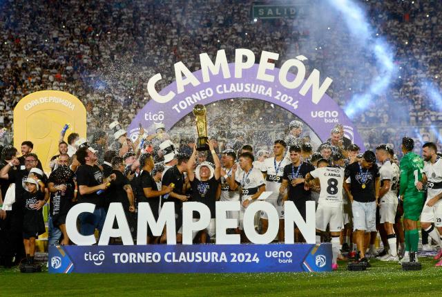 Olimpia's players lift the trophy after winning the Paraguayan league final football match between Olimpia and Nacional at Defensores del Chaco Stadium in Asuncion on November 24, 2024. (Photo by Daniel Duarte / AFP)