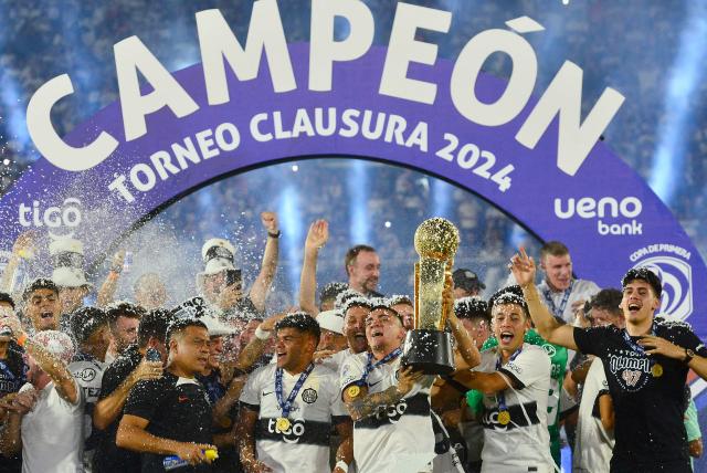 Olimpia's players lift the trophy after winning the Paraguayan football league final football match between Olimpia and Nacional at Defensores del Chaco Stadium in Asuncion on November 24, 2024. (Photo by Daniel Duarte / AFP)