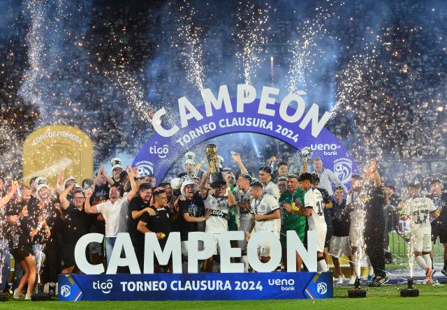 Olimpia's players lift the trophy after winning the Paraguayan football league final football match between Olimpia and Nacional at Defensores del Chaco Stadium in Asuncion on November 24, 2024. (Photo by Daniel Duarte / AFP)