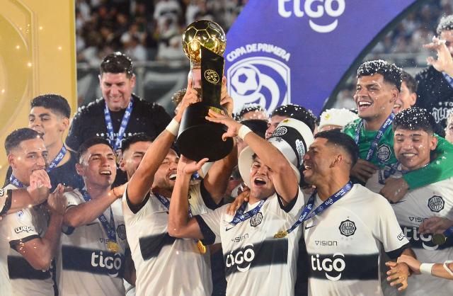 Olimpia's players lift the trophy after winning the Paraguayan league final football match between Olimpia and Nacional at Defensores del Chaco Stadium in Asuncion on November 24, 2024. (Photo by Daniel Duarte / AFP)