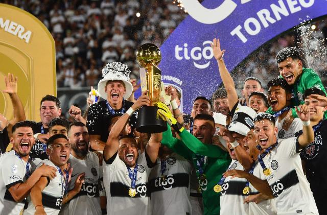 Olimpia's players lift the trophy after winning the Paraguayan league final football match between Olimpia and Nacional at Defensores del Chaco Stadium in Asuncion on November 24, 2024. (Photo by Daniel Duarte / AFP)