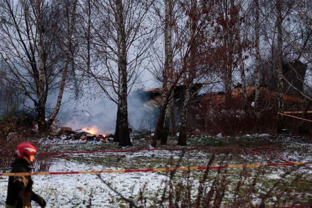 A Lithuanian rescuer walks past the wreckage of a cargo plane following its crash near the Vilnius International Airport in Vilnius on November 25, 2024. (Photo by Petras MALUKAS / AFP)