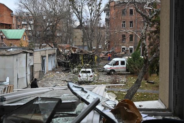 Ukrainian law enforcement officers work in the courtyard of a damaged residential building following a missile attack in Kharkiv on November 25, 2024. (Photo by SERGEY BOBOK / AFP)