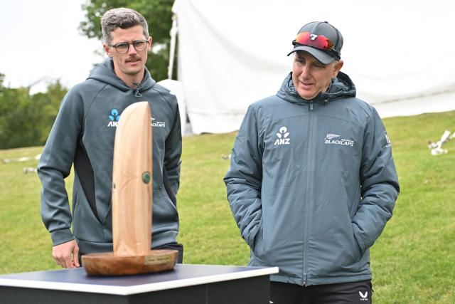 New Zealand's coach Gary Stead (R) inspects the Crowe-Thorpe trophy, honoring late New Zealand's Martin Crowe and England's Graham Thorpe, two days before the first Test cricket match between England and New Zealand at Hagley Oval in Christchurch on November 26, 2024. (Photo by Sanka Vidanagama / AFP)