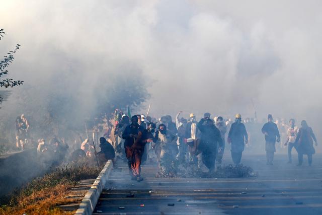 Policemen fire tear gas shells to disperse supporters of Pakistan Tehreek-e-Insaf (PTI) party during a protest to demand the release of former prime minister Imran Khan, in Islamabad on November 26, 2024. Thousands of protestors calling for the release of Pakistan's jailed ex-prime minister Imran Khan defied roadblocks and tear gas to march to the gates of the nation's capital on November 26. (Photo by Aamir QURESHI / AFP)