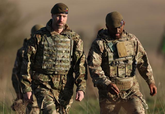 Britain's Prince William, Prince of Wales (L) talks with a member of the 1st Battalion Welsh Guards during his visit to an Army firing range facility on Salisbury Plain, in southern England on November 26, 2024. (Photo by Adrian Dennis / AFP)