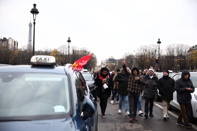 Taxi drivers take part in a protest against lower mileage rates for patient transport, in Paris on December 3, 2024. (Photo by Anne-Christine POUJOULAT / AFP)