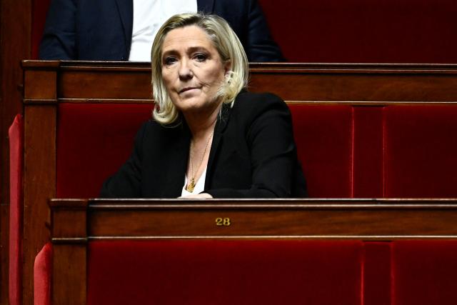 President of Rassemblement National parliamentary group Marine Le Pen looks on during a session of questions to the government at The National Assembly in Paris on December 3, 2024. On December 3, 2024 the Conference of Presidents of the National Assembly is expected to decide on the date for the debate and vote on a motion of no confidence, which has every chance of being approved, as the Nouveau Front Populaire (NFP) and the Rassemblement National (RN) have announced that they will vote in its favour. (Photo by JULIEN DE ROSA / AFP)