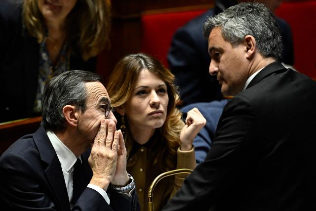 France's Interior Minister of the Interior Bruno Retailleau (L) and French government's spokesperson Maud Bregeon (C) speak to France's former Interior Minister and French Member of Parliament for ruling party Renaissance Gerald Darmanin during a session of questions to the government at The National Assembly in Paris, on December 3, 2024. On December 3, 2024, the Conference of Presidents of the National Assembly is expected to decide on the date for the debate and vote on a motion of no confidence, which has every chance of being approved, as the Nouveau Front Populaire (NFP) and the Rassemblement National (RN) have announced that they will vote in its favour. (Photo by JULIEN DE ROSA / AFP)