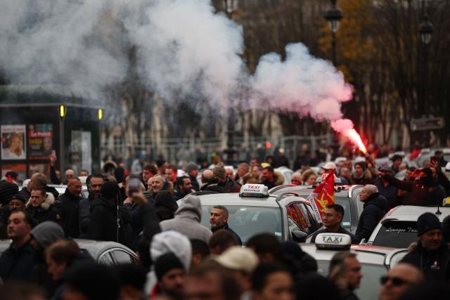 Taxi drivers take part in a protest against lower mileage rates for patient transport, in Paris on December 3, 2024. (Photo by Anne-Christine POUJOULAT / AFP)