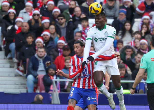 Getafe's Nigerian midfielder #06 Chrisantus Uche heads the ball challenged by Atletico Madrid's Uruguayan defender #02 Jose Gimenez (L) during the Spanish league football match between Club Atletico de Madrid and Getafe CF at the Metropolitano stadium in Madrid on December 15, 2024. (Photo by Pierre-Philippe MARCOU / AFP)