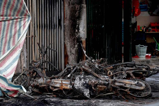 Charred belongings are seen outside a burnt house following a fire at a karaoke bar in Hanoi on December 19, 2024. A fire that ripped through a karaoke bar in the Vietnamese capital killed 11 people and injured two others in a suspected arson attack, police said on December 19. (Photo by Nam NGUYEN / AFP)