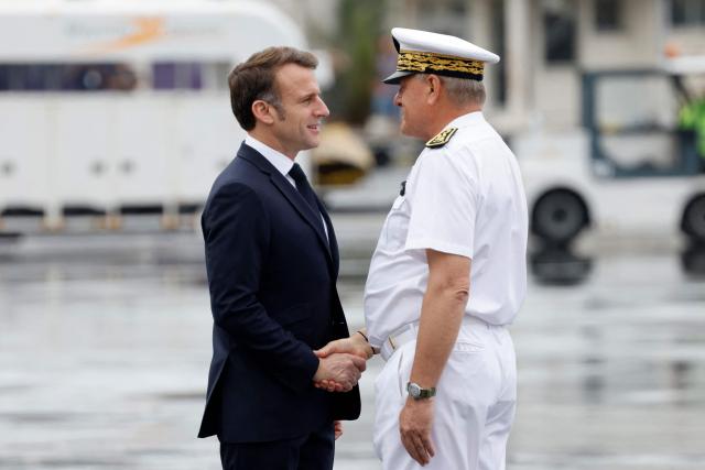 France's President Emmanuel Macron (L) shakes hands with Mayotte's Prefect François-Xavier Bieuville, as he arrives on the tarmac of Dzaoudzi's airport, on the French Indian Ocean territory of Mayotte, on December 19, 2024, following the cyclone Chido's passage over the archipelago. French President Emmanuel Macron on December 19, 2024, arrived in Mayotte to assess the devastation wrought by Cyclone Chido on the Indian Ocean archipelago, as rescuers raced to search for survivors, an AFP journalist said. Macron's plane landed at 10:10 am local time (0710 GMT) with some twenty doctors, nurses and civil security personnel on board, as well as four tonnes of food and sanitary supplies. (Photo by Ludovic MARIN / POOL / AFP)