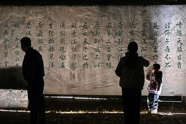 People are seen at a park next to the Yangtze River in Wuhan in China's central Hubei province on December 20, 2024, ahead of the fifth anniversary of China confirming its first death from the Covid-19 coronavirus. (Photo by HECTOR RETAMAL / AFP)