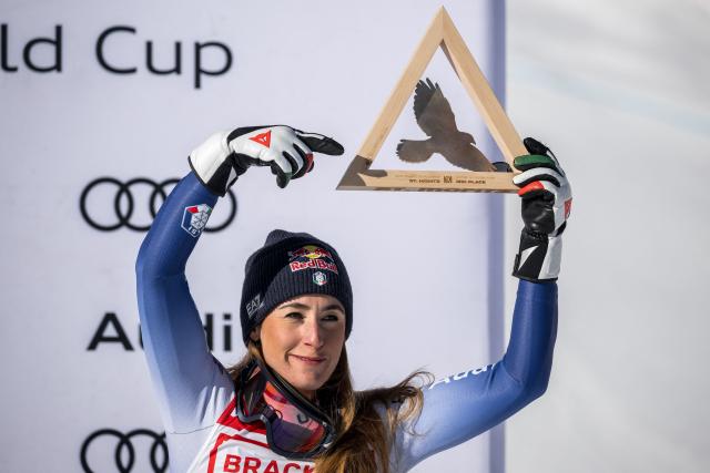 Third placed Italy's Sofia Goggia celebrates on the podium after the Women's Super-G race as part of the FIS Alpine ski World Cup 2024-2025, in St. Moritz on December 21, 2024. (Photo by Fabrice COFFRINI / AFP)