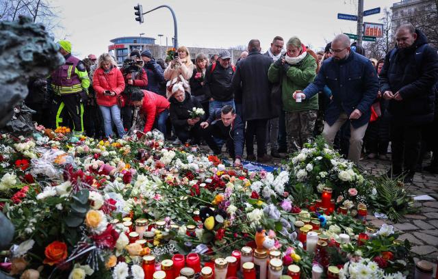 Well wishers lay flowers near the site of a car-ramming attack on a Christmas market in Magdeburg, eastern Germany, on December 21, 2024, resulting in several deaths and dozens of injured. The death toll in the attack on December 20, rose to 5 on December 21, 2024, with over 200 injured, according to the head of the regional government, Reiner Haseloff. (Photo by Ronny HARTMANN / AFP)