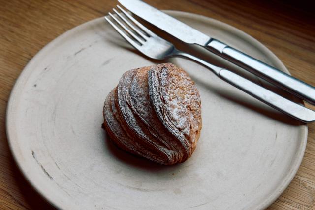 A croissant dough mince pie is pictured at Pophams bakery in London on December 20, 2024. "We have great respect for the classic shortcrust mince pie, but we believe in the power of innovation — especially when it creates something so delicious," said Pophams' creative director Lucy McWhirter. The bakery uses its signature croissant dough for a mince pie filled with classic mincemeat and citrus and ginger flavoured cream. (Photo by BENJAMIN CREMEL / AFP)