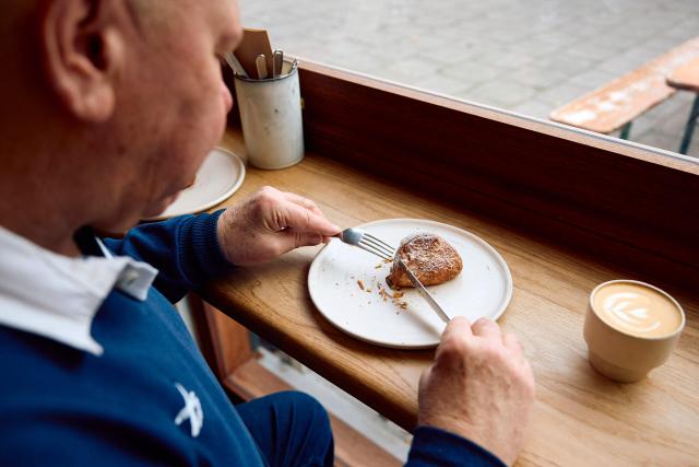 A person is pictured eating a croissant dough mince pie at Pophams bakery in London on December 20, 2024. "We have great respect for the classic shortcrust mince pie, but we believe in the power of innovation — especially when it creates something so delicious," said Pophams' creative director Lucy McWhirter. The bakery uses its signature croissant dough for a mince pie filled with classic mincemeat and citrus and ginger flavoured cream. (Photo by BENJAMIN CREMEL / AFP)