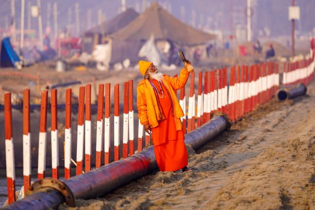 A sadhu or a Hindu holy man, takes his selfie near Sangam, the confluence of Ganges, Yamuna and mythical Saraswati rivers, ahead of the Maha Kumbh Mela festival in Prayagraj on December 22, 2024. (Photo by HIMANSHU SHARMA / AFP)