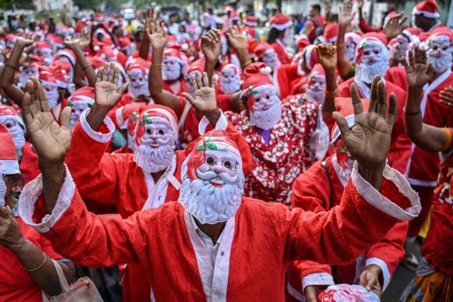 People dressed as Santa Claus dance during an event as a part of Christmas celebrations in Chennai on December 22, 2024. (Photo by R.Satish BABU / AFP)