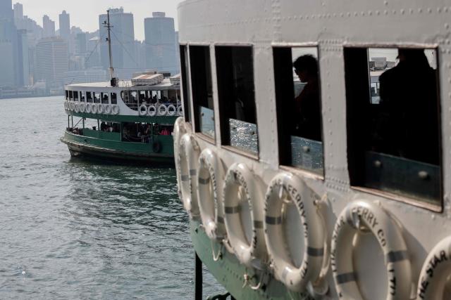 Commuters are seen on board a Star Ferry which crosses Victoria Harbour as another Star Ferry sails in the background in Hong Kong on December 22, 2024. (Photo by David GANNON / AFP)